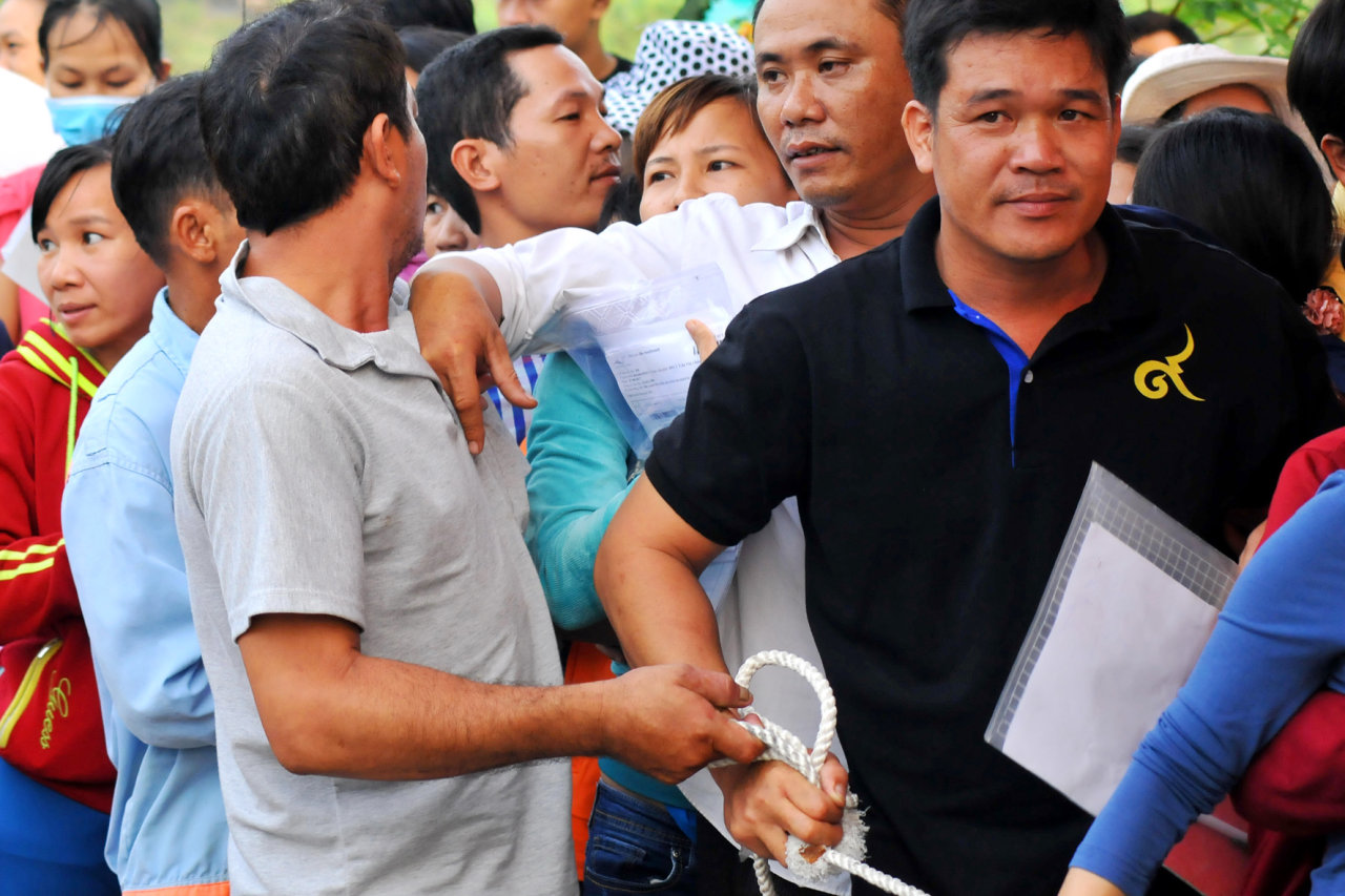 A parent is shooed away as he tries to cut in line. Photo: Tuoi Tre
