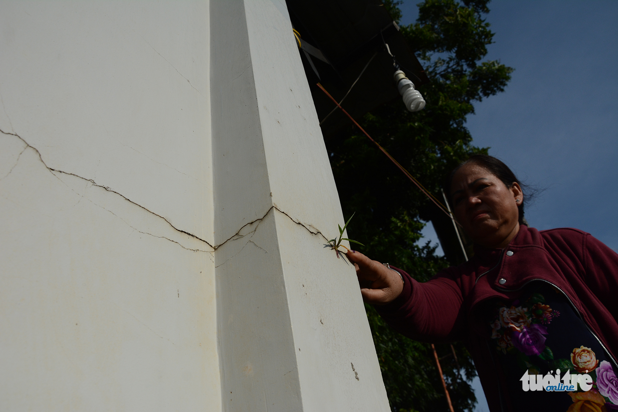 A local points at a large crack on the walls of her house caused by titanium mining activities in Binh Thuan Province. Photo: Tuoi Tre