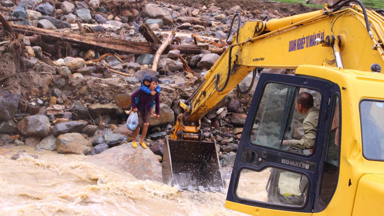 ​In Vietnam, excavator bucket ferries stranded villagers over swollen stream