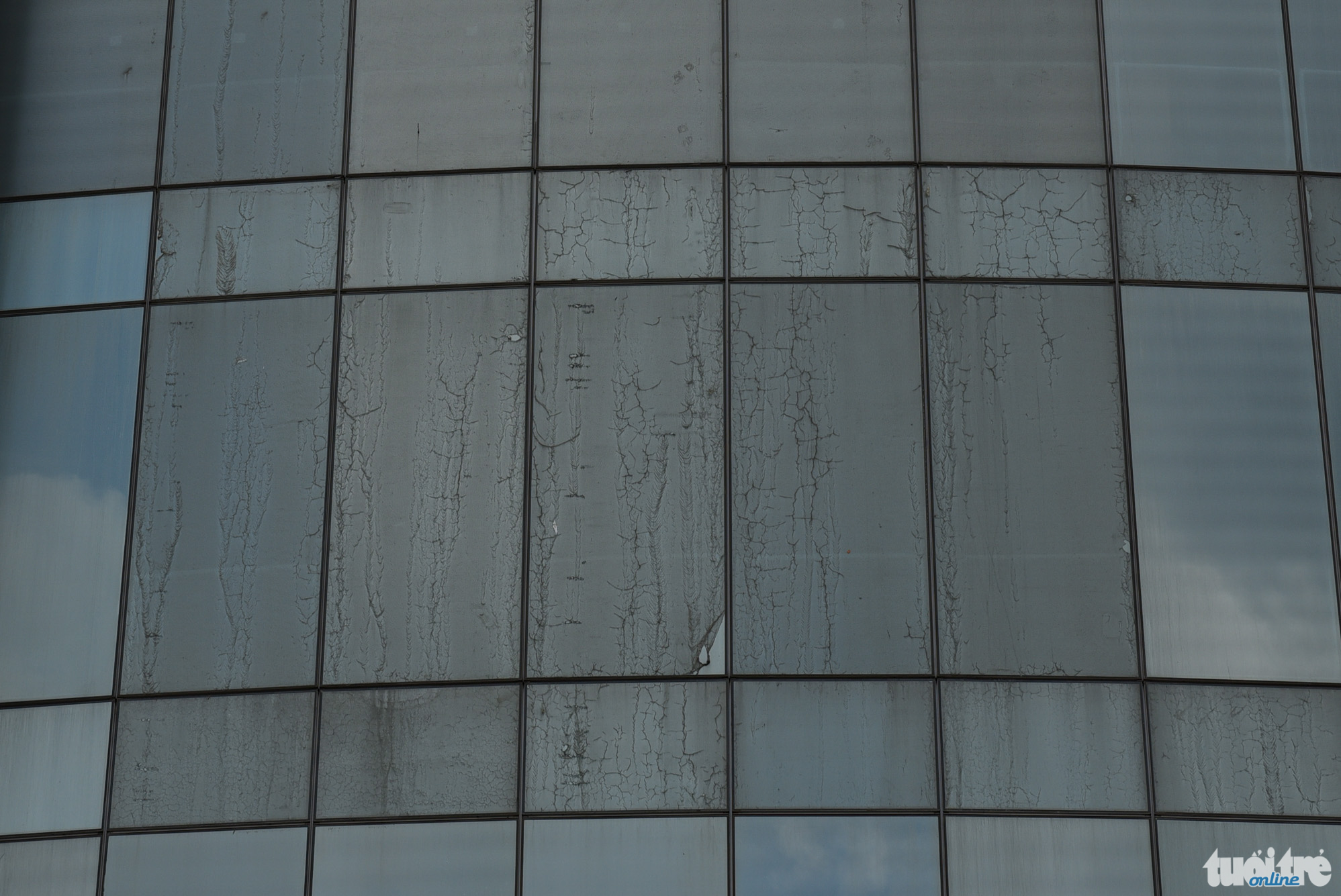 Dust covers the glass windows of the high-rise building.