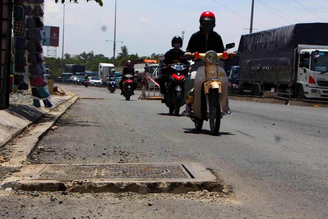 A manhole cover is 10 centimeter higher than the rest of the street. Photo: Tuoi Tre