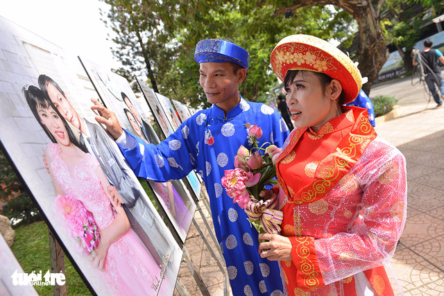 A couple look at their wedding photo sponsored by the city. Photo: Tuoi Tre