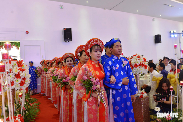 Couples enter the wedding hall at the Queen Plaza Ky Hoa wedding center for the main ceremony. Photo: Tuoi Tre