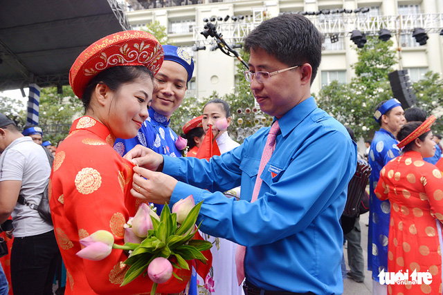 A couple are presented with commemorative badges by city leaders. Photo: Tuoi Tre