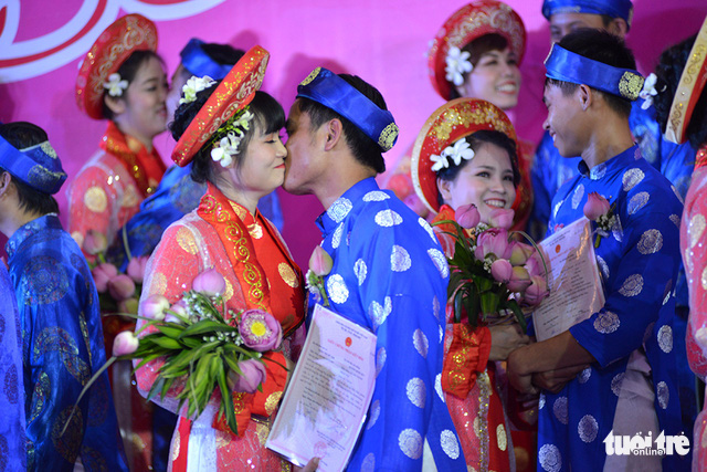 Couples exchange their first kiss as husbands and wives during a mass wedding organized in Ho Chi Minh City, September 2, 2017. Photo: Tuoi Tre