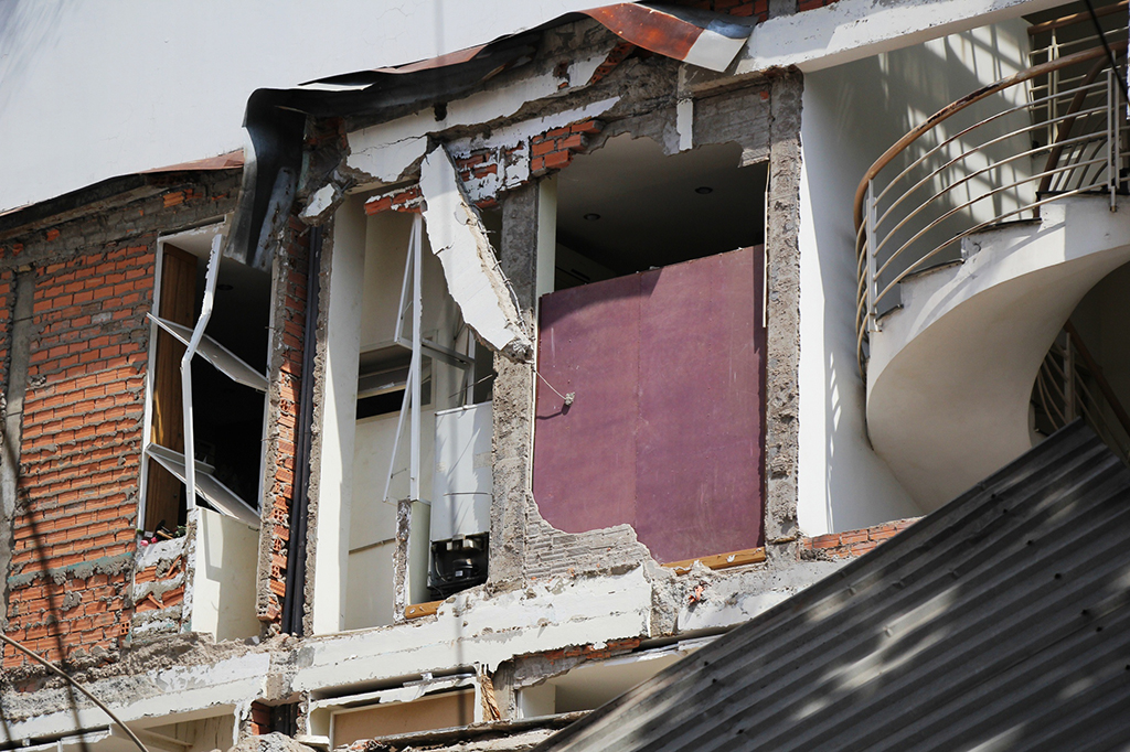Patches of the walls of nearby houses are torn apart in the collapse. Photo: Tuoi Tre