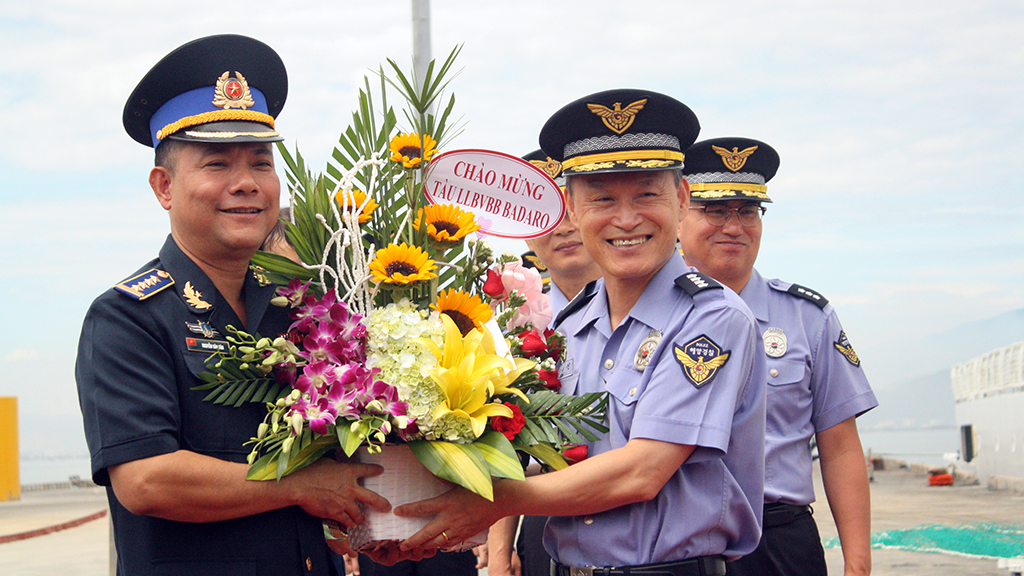 An officer from the High Command of Vietnam Coast Guard (L) presents flowers to Kim Dong Jin, head of human resource at the Korean Coast Guard Institute, at Tien Sa Seaport in Da Nang City, September 4, 2017. Photo: Tuoi Tre