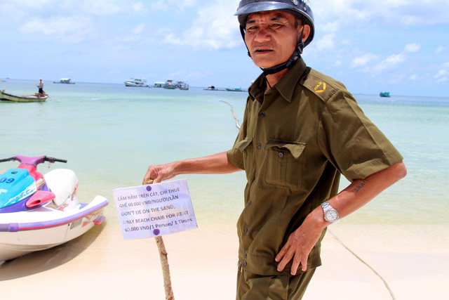 Tran Van Hue is pictured with the sign before removing it.