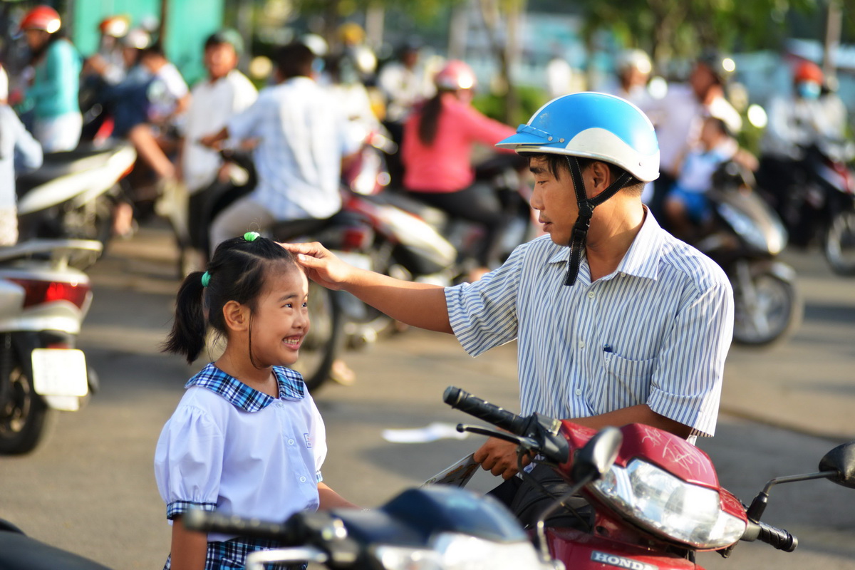 A man fixes his daughter’s hair as he drops her off at Tam Vu Elementary School in Ho Chi Minh City, September 5, 2017. Photo: Tuoi Tre