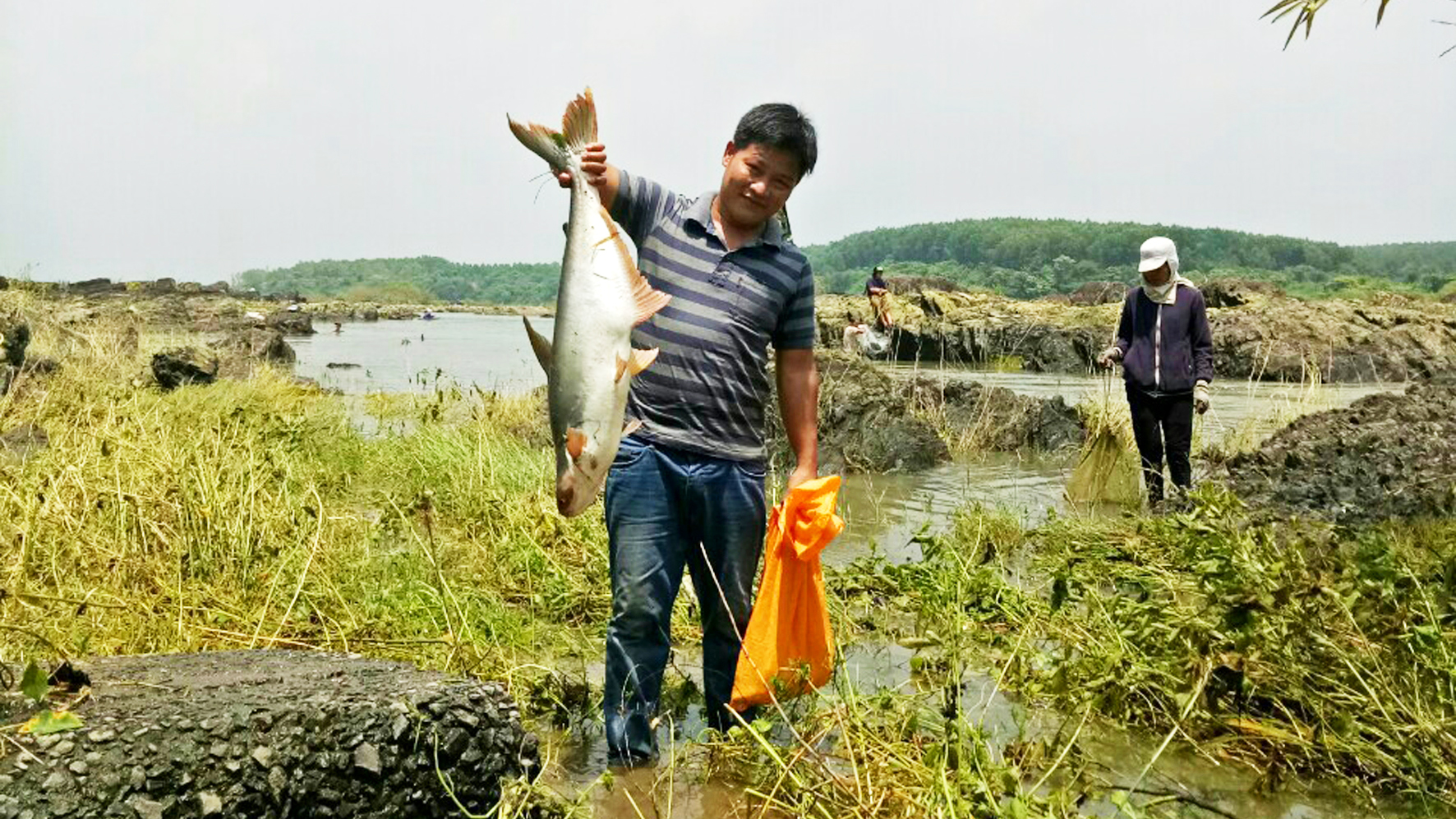 A local resident shows off a fish he has just caught.