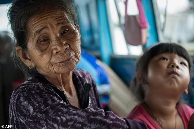 Kim Hui, 70, and her five-year-old granddaughter Nguyen Thi Ngoc Huyen sit inside a boat that they call home in a canal off the Hau River at the floating Cai Rang Market in Can Tho, a small city in the Mekong Delta. Photo: AFP