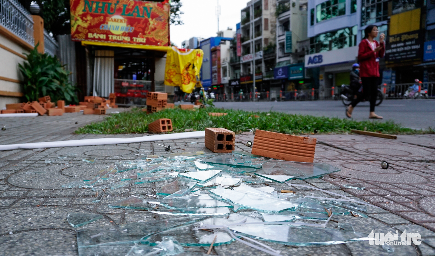 Shattered glass is seen on the sidewalk near a mooncake stand. Photo: Tuoi Tre