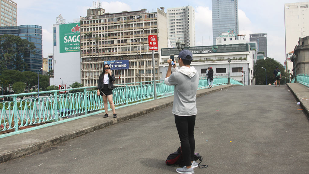 A couple take photos on the Mong Bridge. Photo: Tuoi Tre