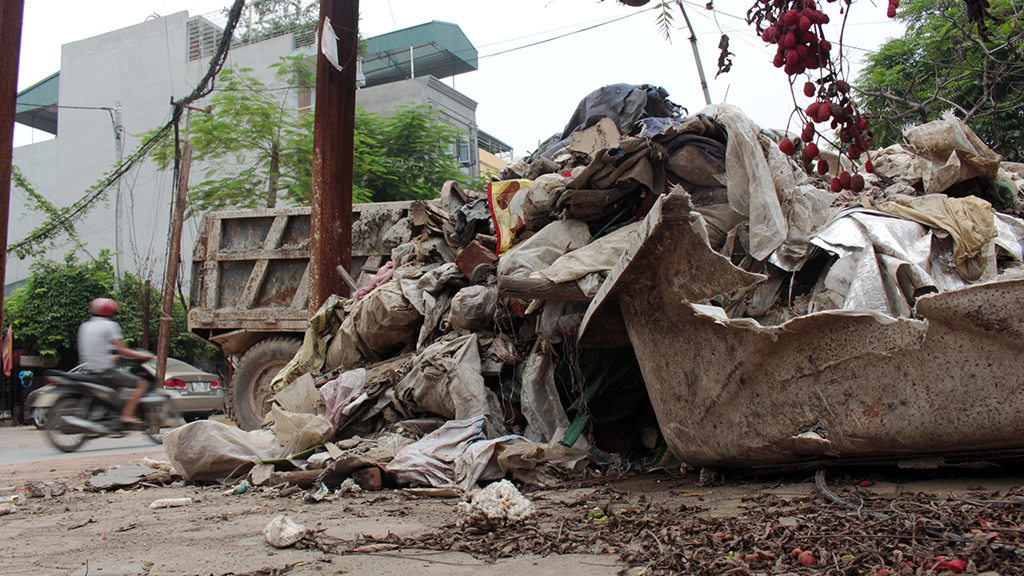 A pile of household garbage and construction waste is seen along a promenade.