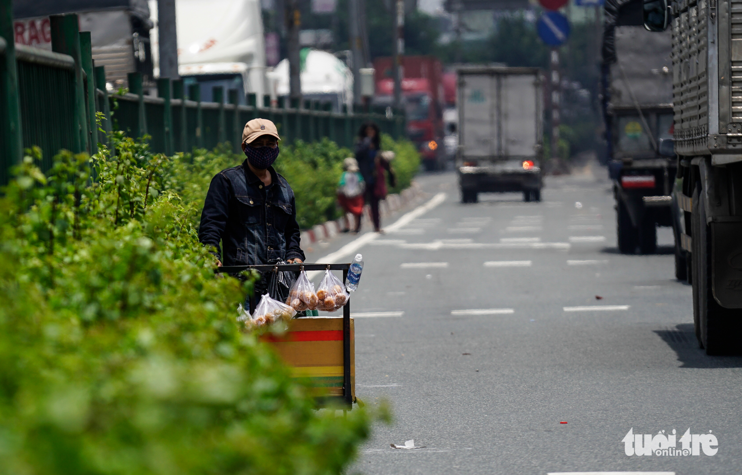 A vendor waits at the side of the road for potential buyers. Photo: Tuoi Tre