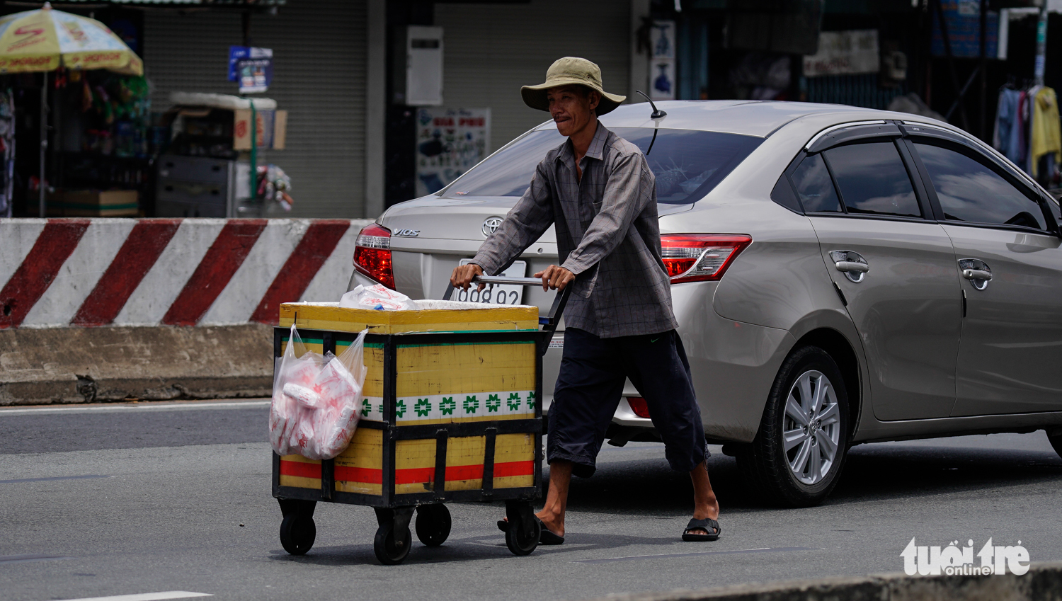 A seller pushes his cart through the middle of the street. Photo: Tuoi Tre