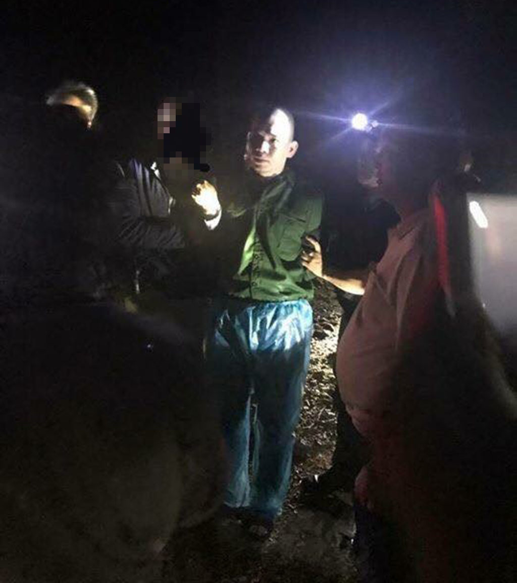 Nguyen Van Tinh (green shirt) is arrested near the entrance to Kia Cave in Mai Chau District, Hoa Binh Province. Photo: Facebook/Hong bien Hoa Binh