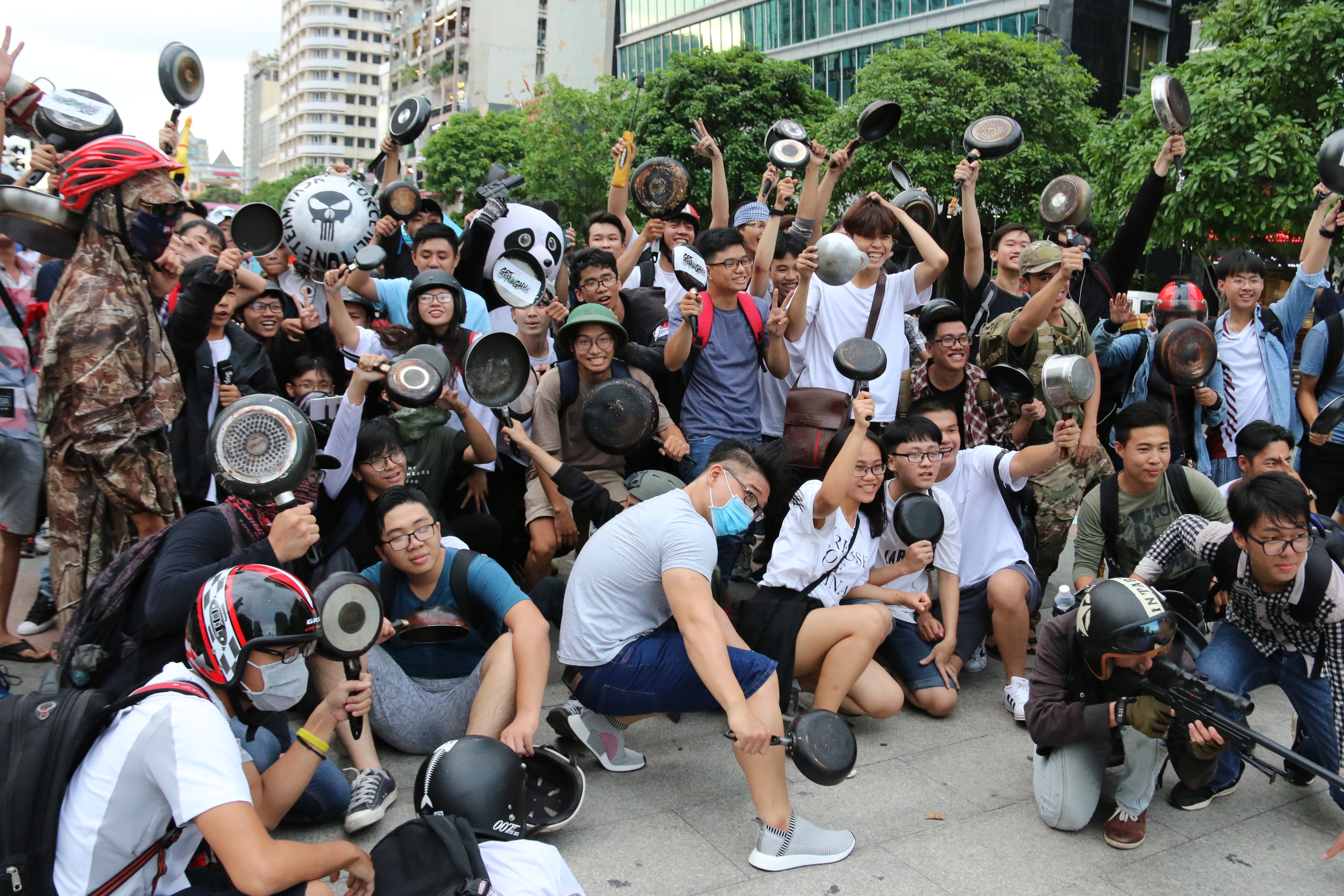 A large group of young people pose with their frying pans.