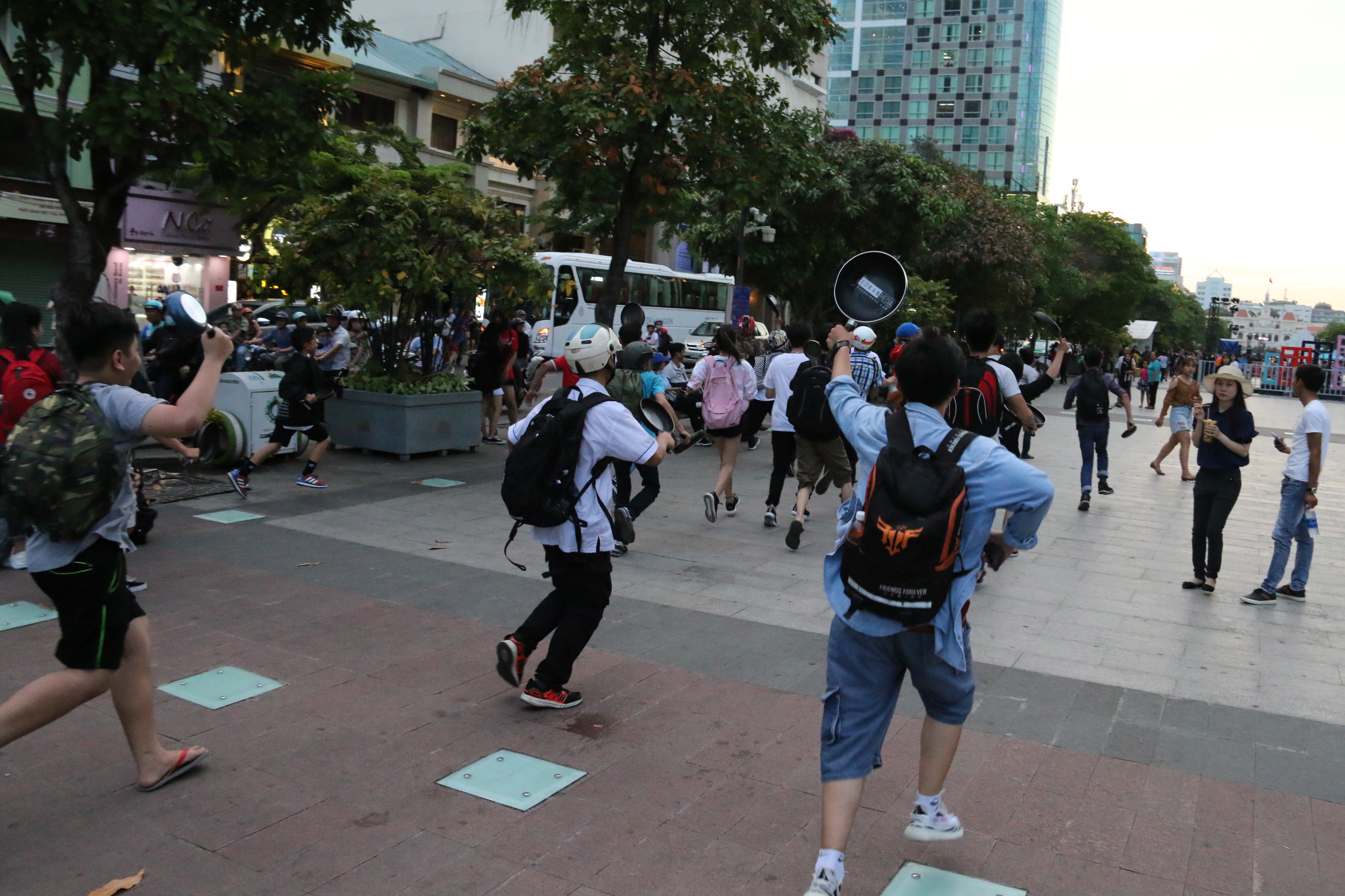Participant runs along the walking street with his frying pans.