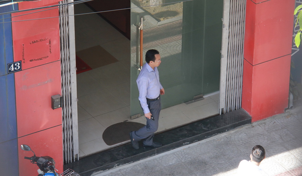 Secretary of the municipal Party Committee Nguyen Xuan Anh walks out of his 45 Nguyen Thai Hoc house, whose address had been removed and now shares the same address with the 43 Nguyen Thai Hoc residence.