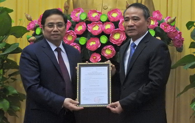 Pham Minh Chinh, chairman of the Organization Commission, hands over the appointment decision to Truong Quang Nghia (R)