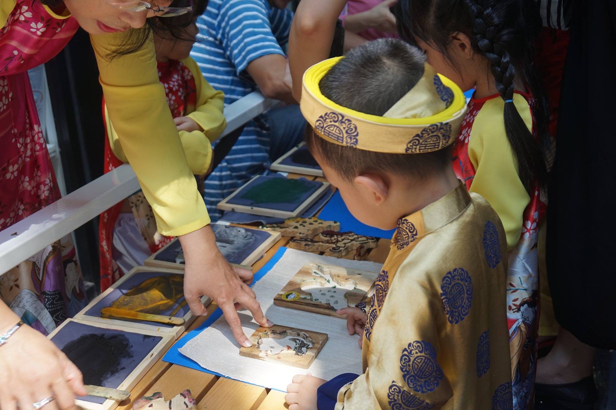 Vietnamese children try printing paintings using woodblocks at an INGO event. Photo: INGO