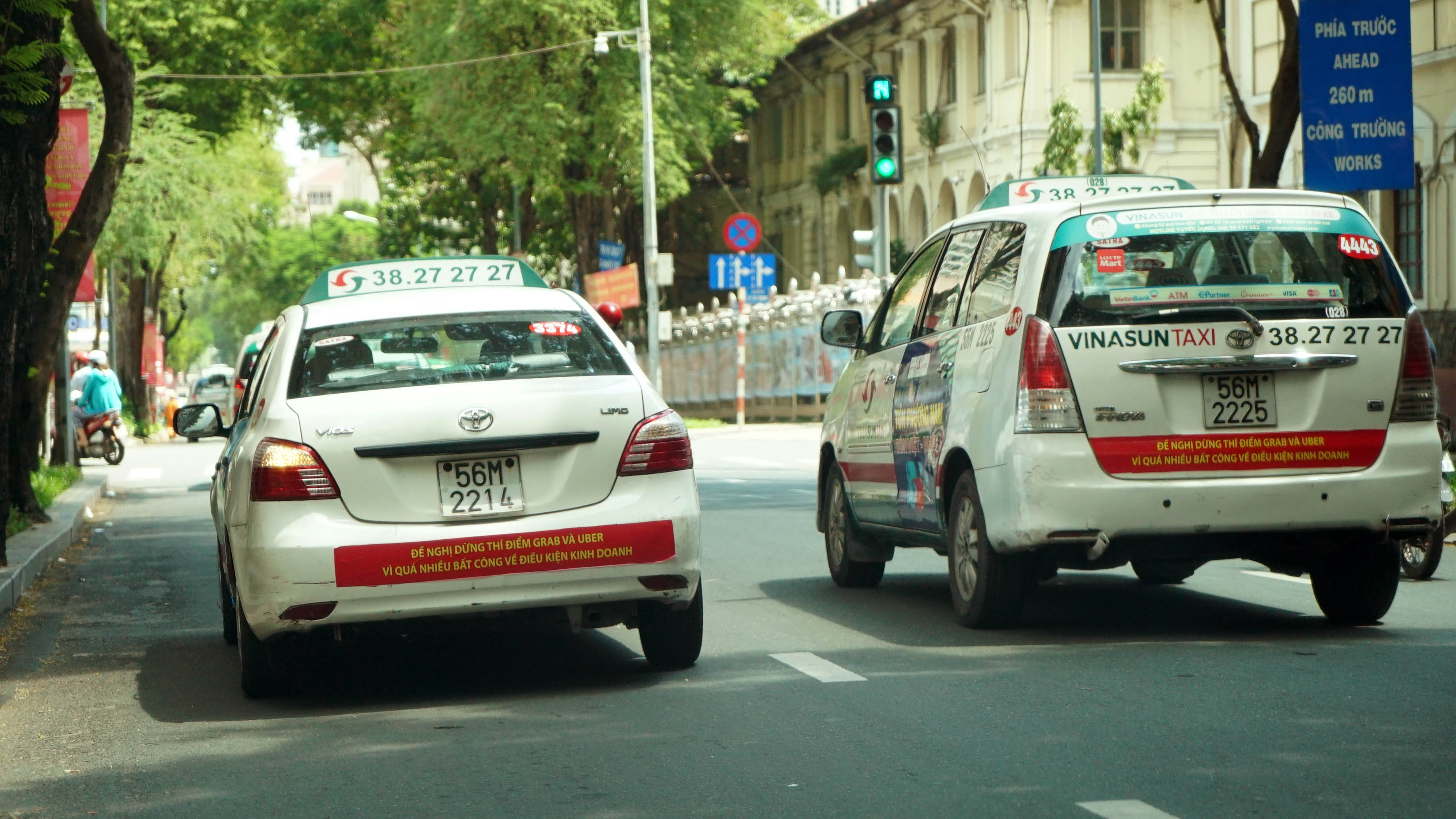 Two Vinasun taxis with anti-Uber and Grab bumper stickers in Ho Chi Minh City. Photo: Tuoi Tre