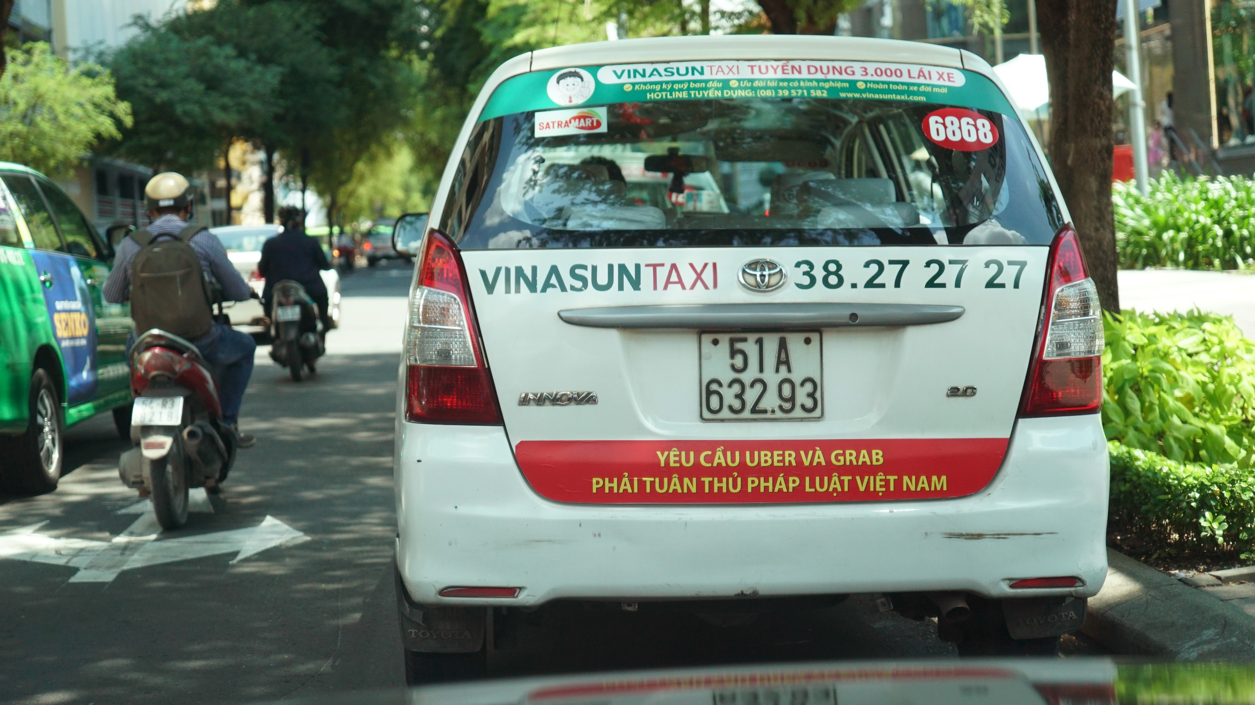 A Vinasun taxi with a bumper sticker carrying the message ‘Uber and Grab must comply with Vietnamese law’ in Ho Chi Minh City. Photo: Tuoi Tre