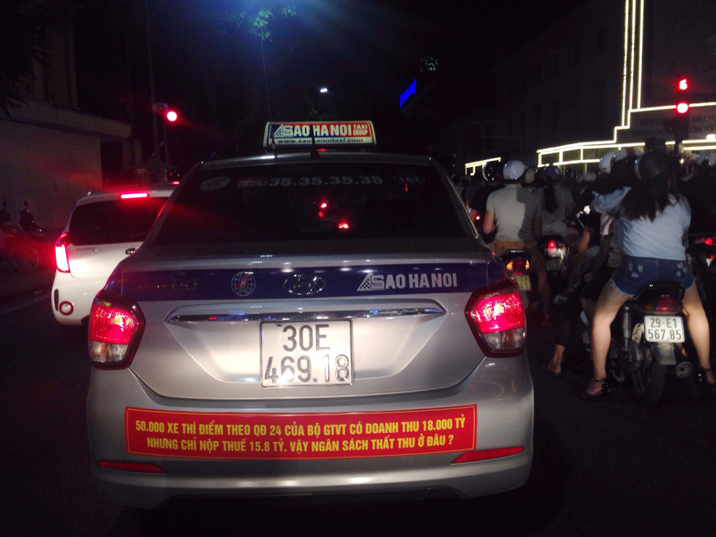 A taxi with an 'anti-Uber, Grab' message is seen in Hanoi.