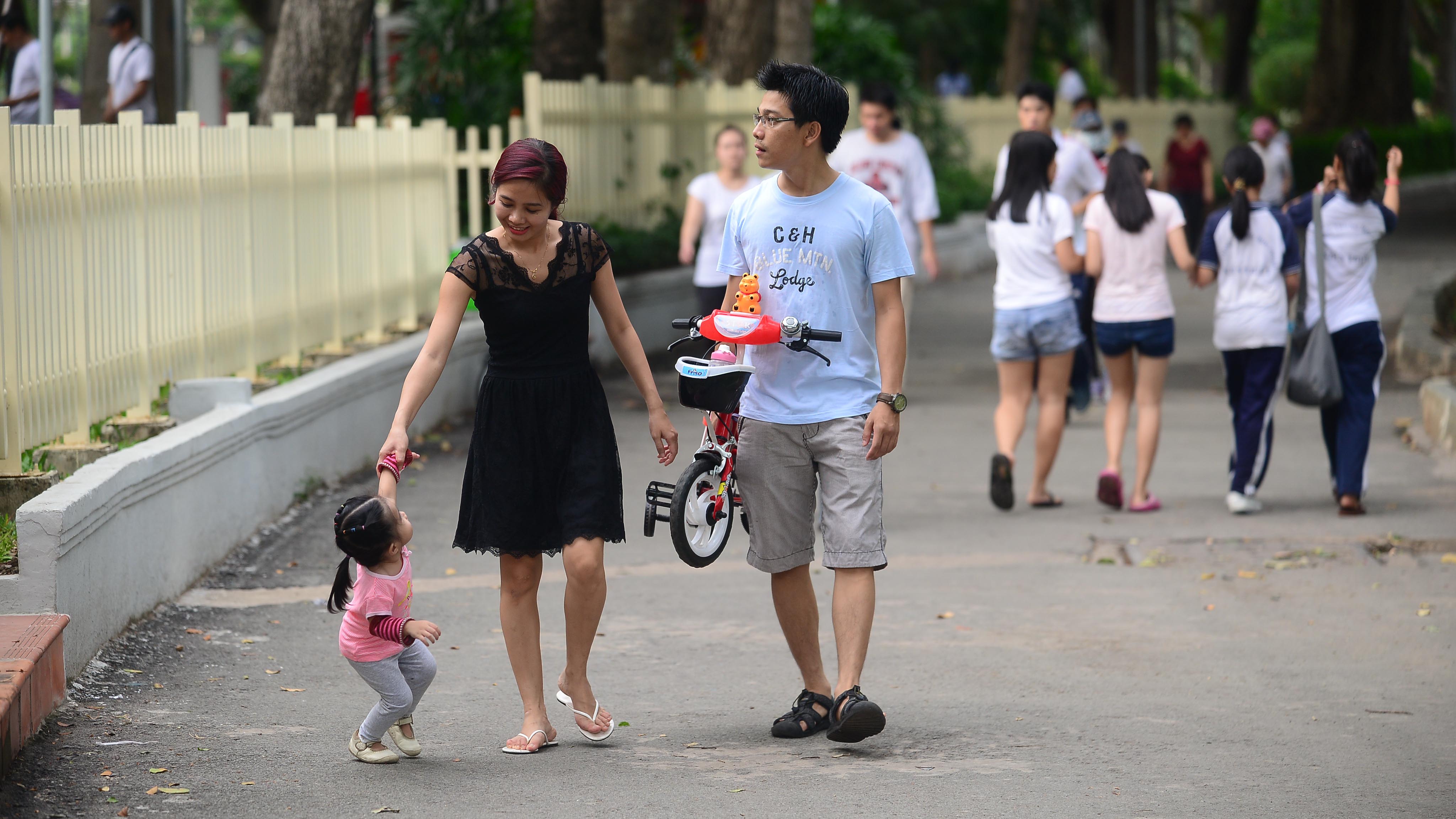A young couple take a stroll with their daughter in Tao Dan Park, Ho Chi Minh City. Photo: Tuoi Tre
