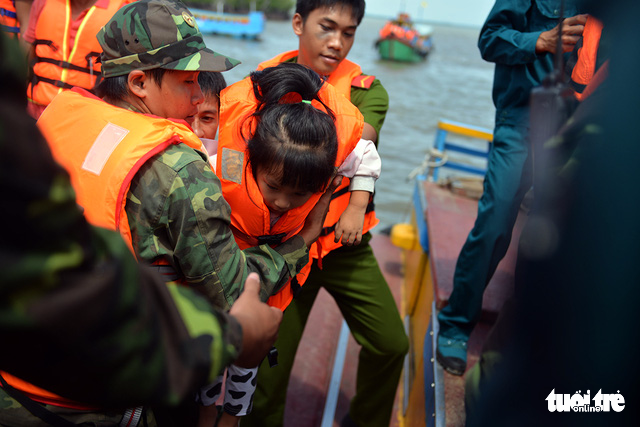 A girl is brought ashore by servicemen and rescue workers during a disaster drill in Can Gio District, Ho Chi Minh City on October 20, 2017. Photo: Tuoi Tre
