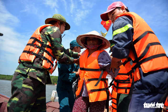 A woman is brought ashore by servicemen and rescue workers during a disaster drill in Can Gio District, Ho Chi Minh City on October 20, 2017. Photo: Tuoi Tre