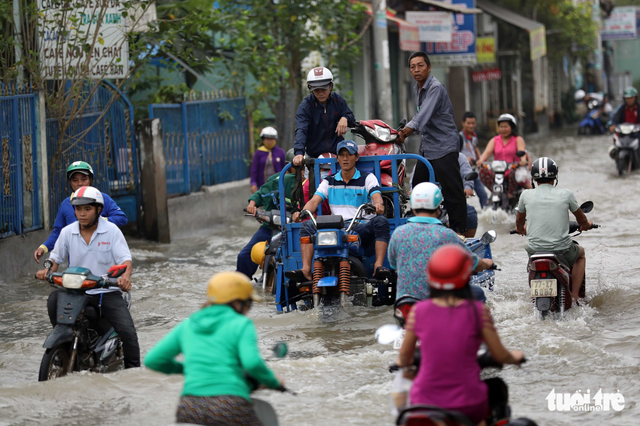 A motorized tricycle carries a broken-down motorcycle.