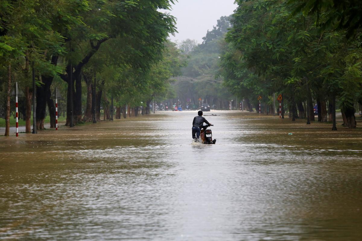 A man pushes his motorcycle along flooded road after typhoon Damrey hits Vietnam in Hue city, Vietnam November 5, 2017. Photo: Reuters