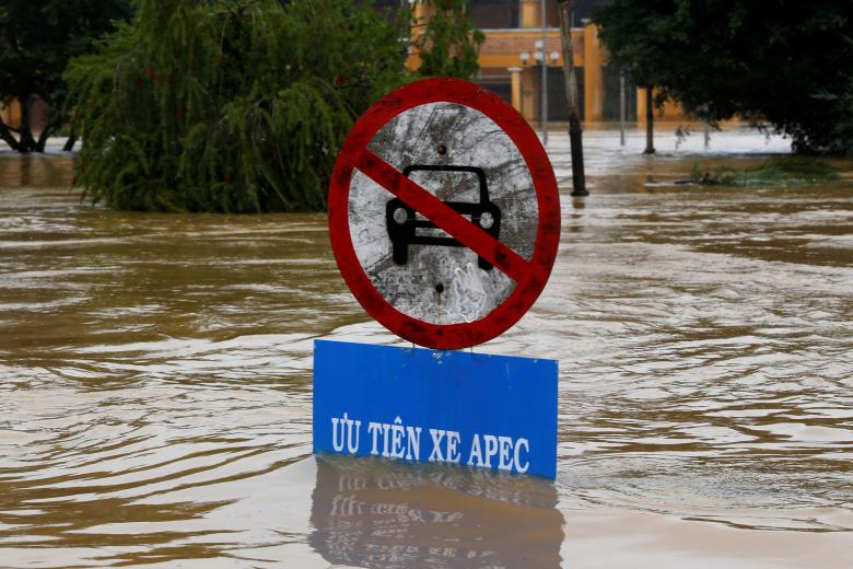 A traffic sing indicating APEC summit vehicles priority is seen along submerged street in Hoi An. Photo: Reuters
