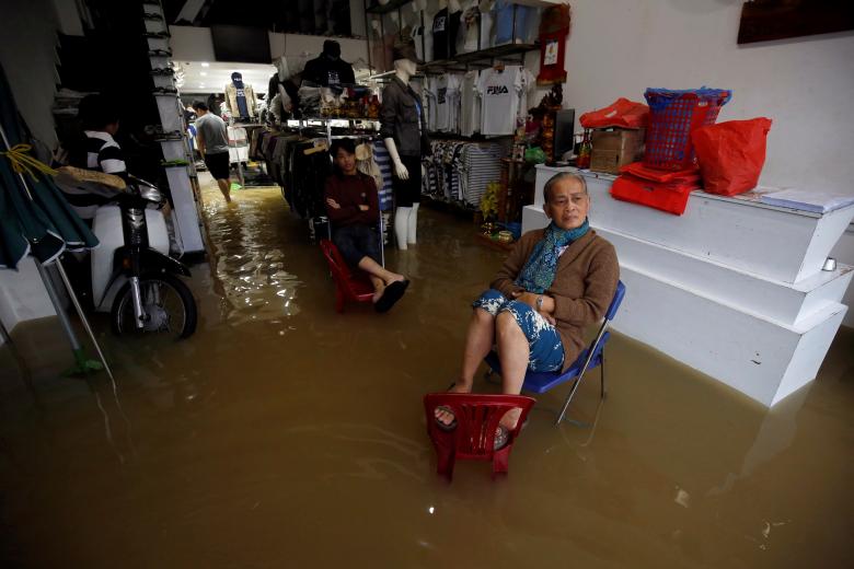 Residents sit on their flooded fashion shop in Hue. Photo: Reuters