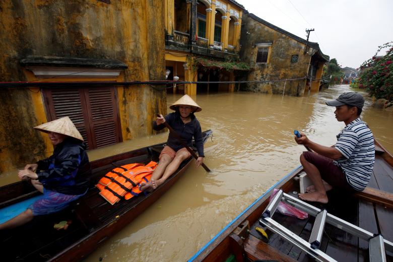 People ride a boat along submerged houses in Hoi An. Photo: Reuters