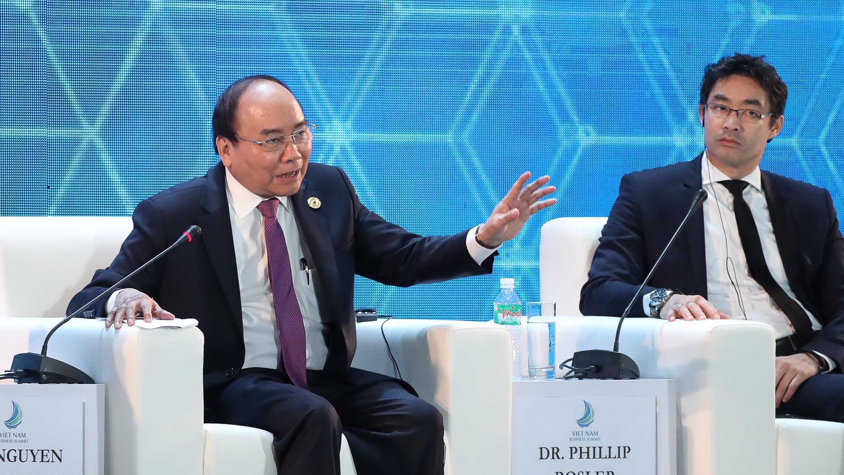 Vietnamese Prime Minister Nguyen Xuan Phuc (L) speaks at a business summit during the APEC Economic Leaders’ Week in Da Nang, November 7, 2017. Photo: Tuoi Tre