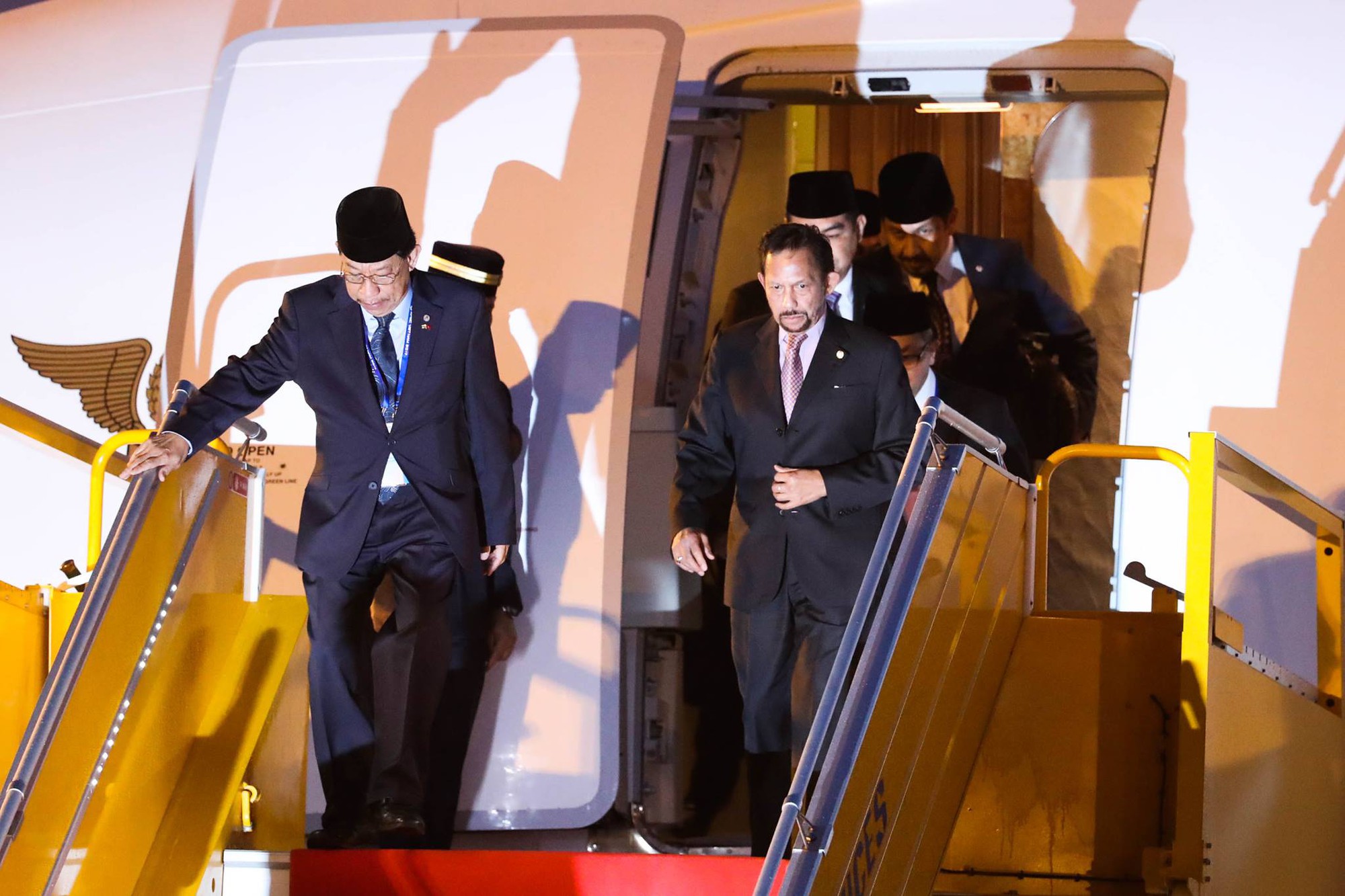 Hassanal Bolkiah (R), the Sultan of Brunei, leaves the aircraft after landing at Da Nang International Airport. Photo: Tuoi Tre