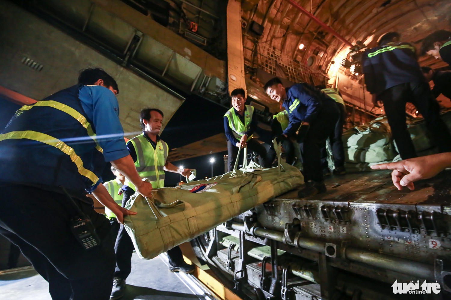 Airport workers help unload goods from the aircraft. Photo: Tuoi Tre