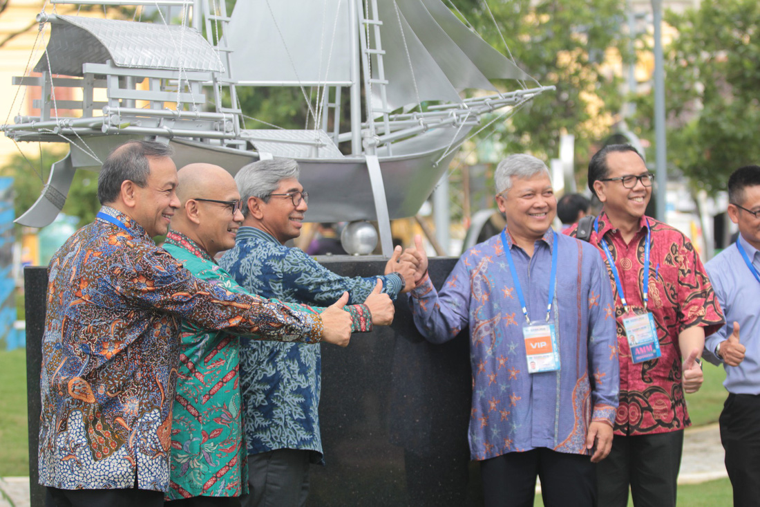 Delegates from Indonesia take pictures with their country’s work