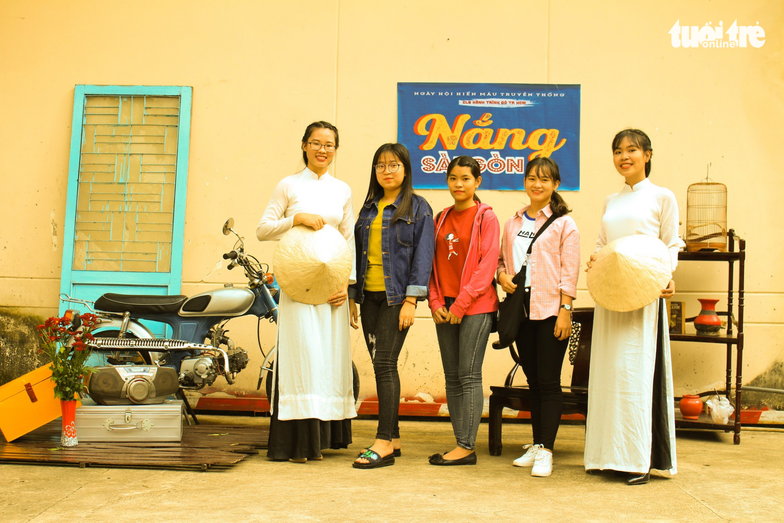 Volunteers in ao dai, the Vietnamese traditional dress, add a touch of antiquity to the event. Photo: Tuoi Tre