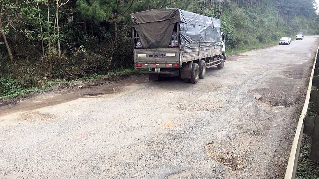 A truck travels in the wrong direction to avoid potholes along the pass.