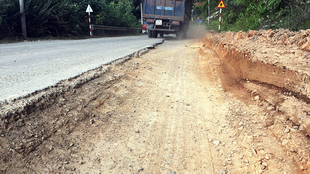 A truck tilts when traveling on the uneven street.