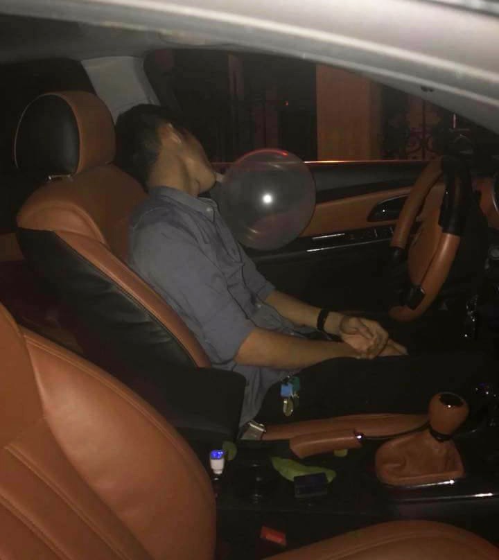 A driver sits in his car with a balloon in his mouth immediately after crashing into several motorcycles Hai Phong. Photo: Tuoi Tre