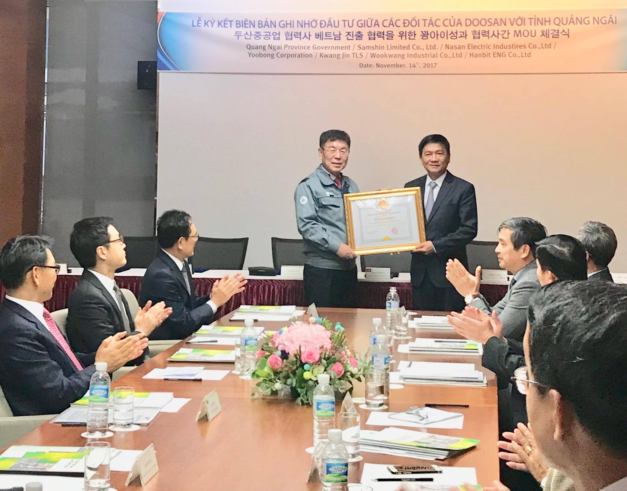 Quang Ngai chairman Tran Ngoc Cang (right) hands over a certificate of merit to Doosan Heavy Industries Vietnam in Quang Ngai, central Vietnam.