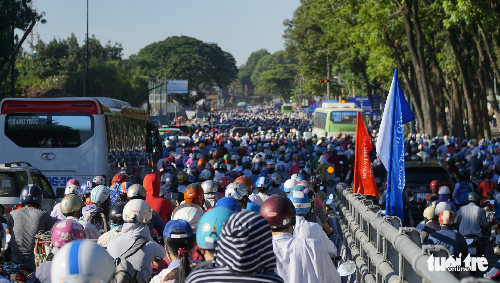 Vehicles descending the bridge waiting at the red light at the intersection of Hoang Minh Giam and Dang Van Sam Streets.