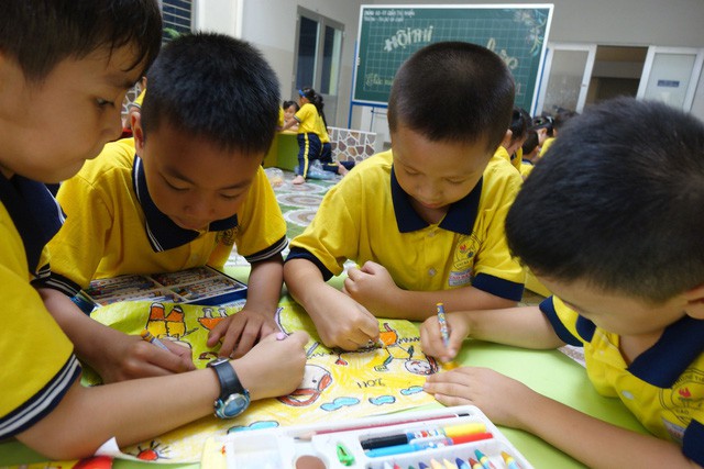 First-grade students at Cao Ba Quat color their drawings.
