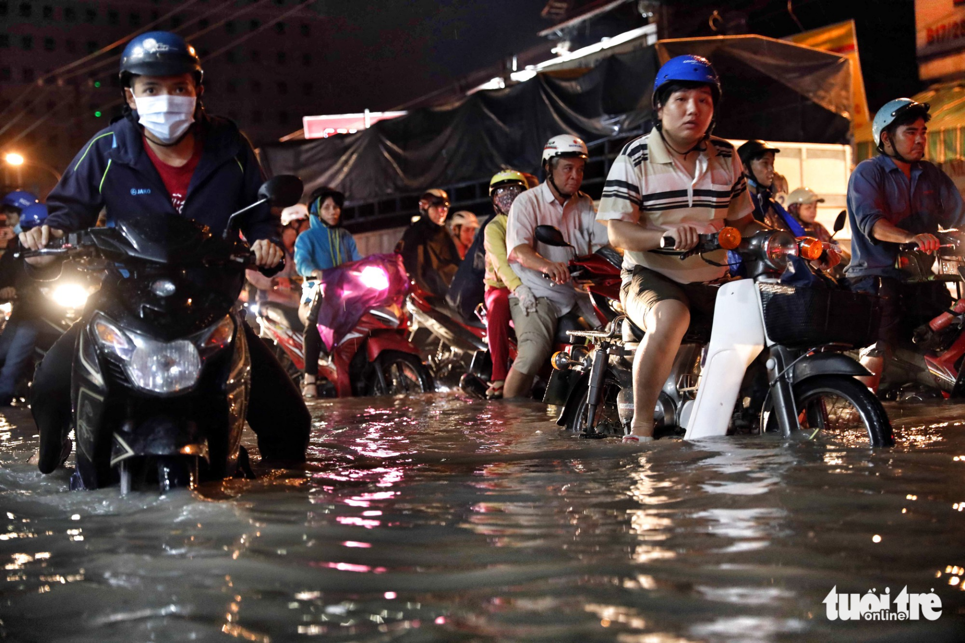 Motorcyclists struggle in floodwaters. Photo: Tuoi Tre