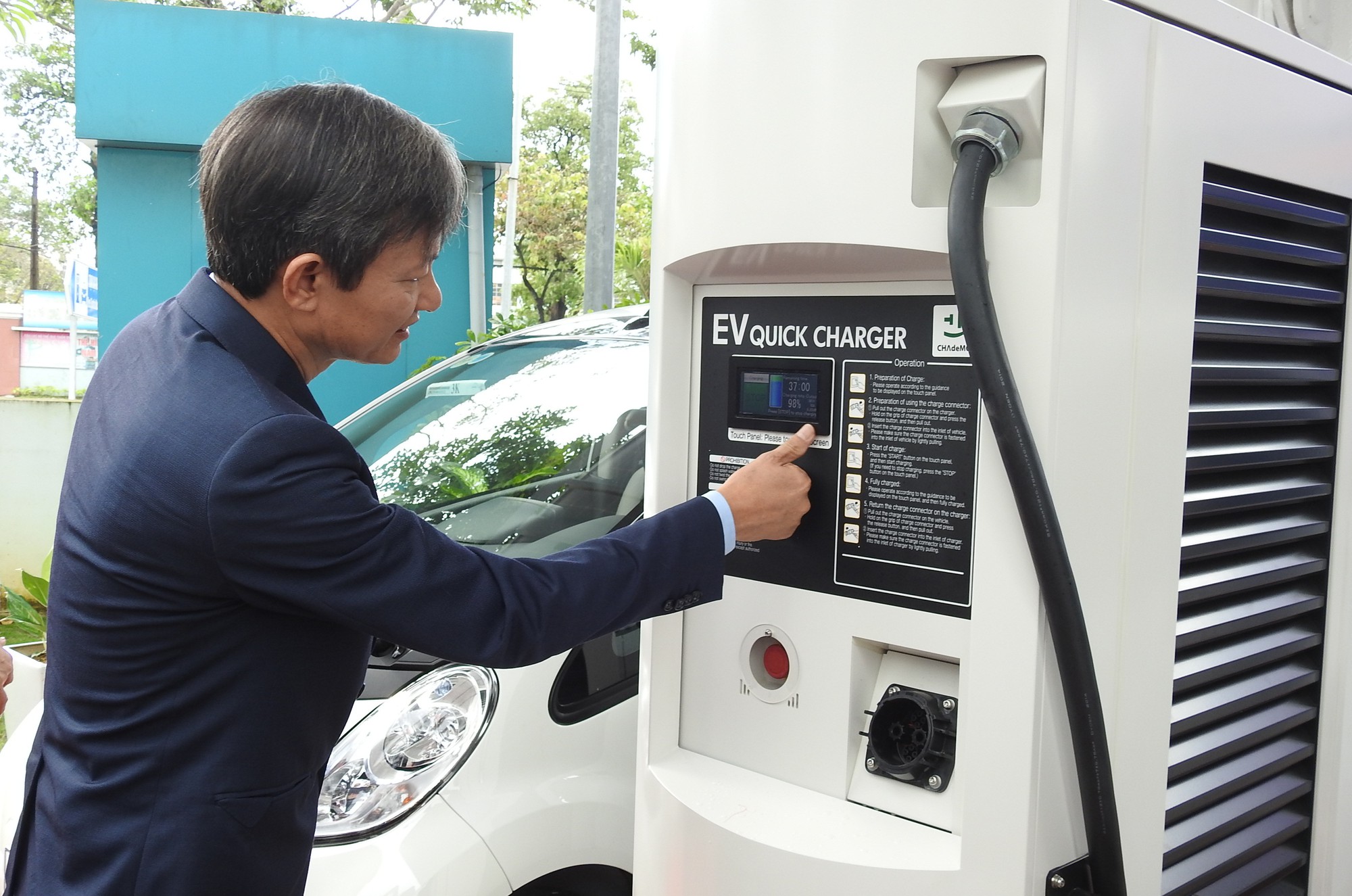 Tran Dinh Nhan operates the electric vehicle quick charger. Photo: Tuoi Tre